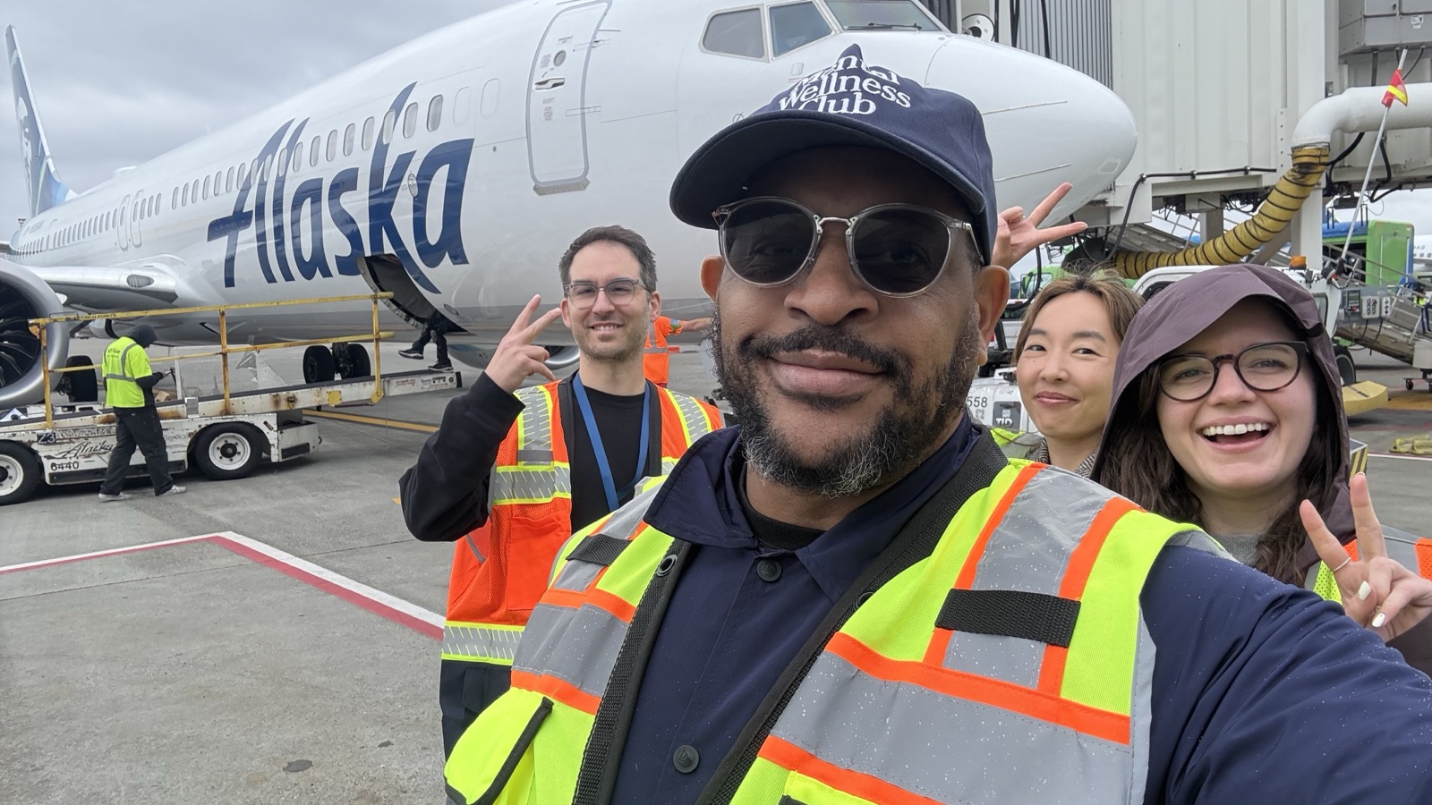 Tre Stewart taking a selfie with Alaska Airlines teammates beside an aircraft during field research